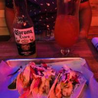 Tacos · Corn tortilla with cabbage, guacamole, onion and salsa, topped with chipotle crema and cotij...