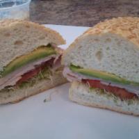 Turkey Avocado Sandwich · Turkey, avocado, sweet red onion, sprouts and tomato on a French roll.