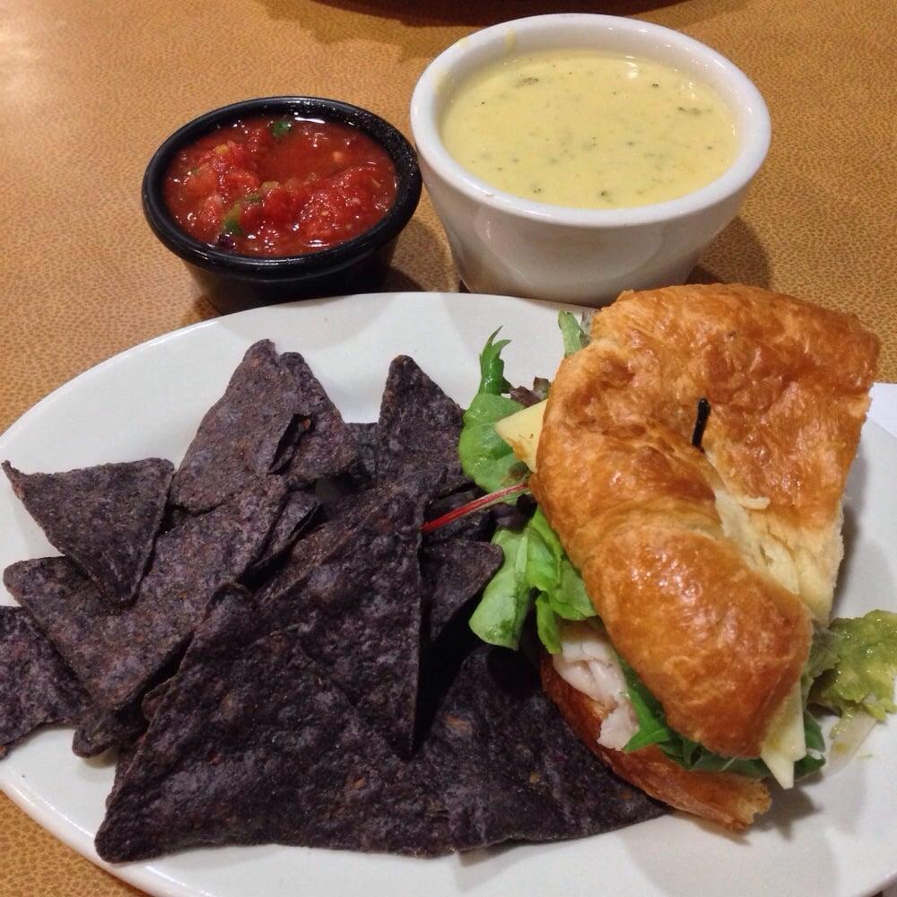 California Club · Roasted turkey breast, bacon, Swiss, guacamole, tomato, organic field greens, mayo, toasted croissant. Served with 1 side: fresh fruit, steamed veggies, baked chips or blue corn chips with salsa.