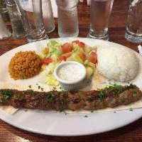Adana Kebab · Koobideh. Grilled and skewered minced lamb, flavored with herbs and served with salad and ri...