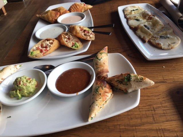 Avocado Club Egg Rolls · Hand-wrapped crispy wonton rolls filled with avocado, chicken, tomato, Monterey Jack and Nueske's Applewood smoked bacon. Served with housemade ranchito sauce and herb ranch.
