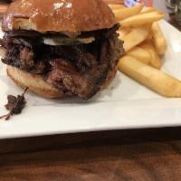 12 Hour Oak Smoked Brisket · Oak smoked brisket on a toasted brioche bun, mustard, house made pickles, and a coffee BBQ s...