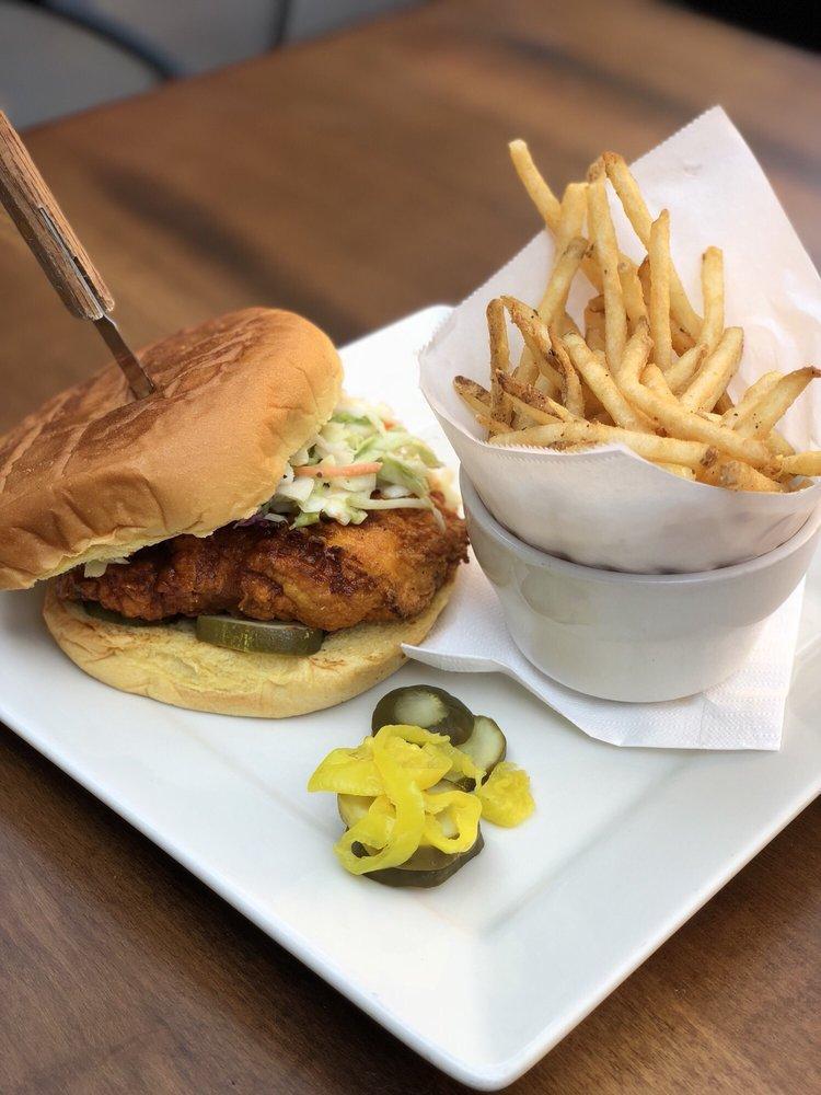 Nashville Hot Chicken Sandwich · Tender, spicy marinated chicken, battered and deep fried, tossed with firkin hot sauce on a white bun with pickle chips.