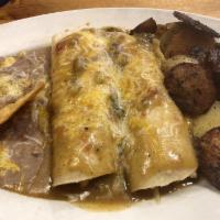 Breakfast Enchiladas · 2 corn tortillas stuffed with scrambled eggs, tomatoes, green chilies and onions. Smothered ...
