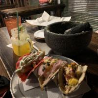 Pink Taco · Pink corn tortilla, battered pacific cod, cilantro crema, pickled onions, smoked jalapeno, a...