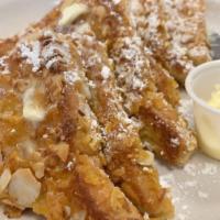 Crunch French Toast · Infused with crispy corn flakes, sliced almonds, and powdered sugar.