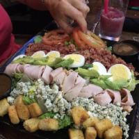 Cobb Salad · Turkey, bacon, eggs, tomatoes, bleu cheese crummbles, croutons and sliced avocado. Comes wit...
