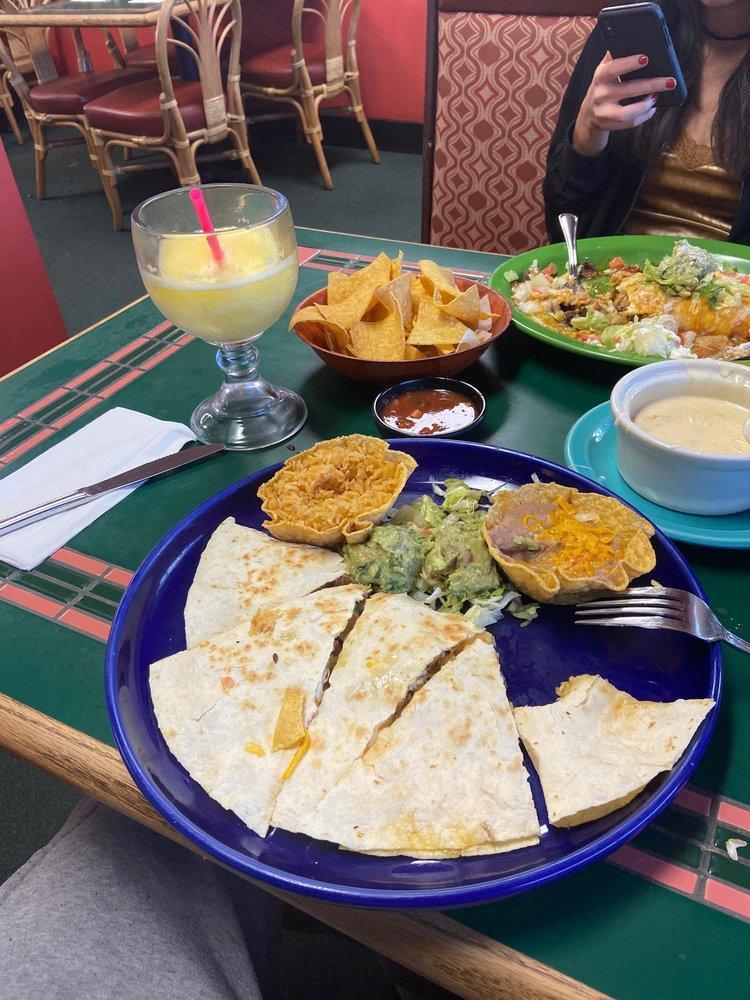 Quesadillas · 2 grilled flour tortillas stuffed with cheddar and Jack cheese, green onions, tomatoes, mild chiles and your choice of chicken, ground beef or picadillo (shredded beef and pork). Served with sour cream, and guacamole.