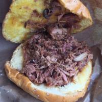 Carolina Chopped Pork Shoulder Sandwich · Served with Carolina BBQ sauce and Texas sidewinders. Served on our house baked potato roll.