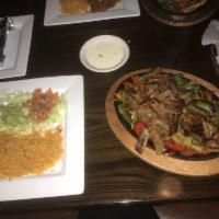 Fajitas · Choice of flank steak, chicken or mixed, served with two flour tortillas, rice, beans and sa...