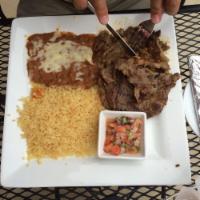 Carne Asada · Grilled tender rib-eye beef served with rice, beans, pico de gallo and 2 flour tortillas.