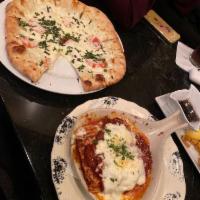 Margherita Pizza · Sliced San Marzano Italian tomatoes, fresh mozzarella, basil and garlic oil. Vegetarian.