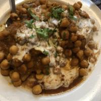 Samosa Chaat · Vegetable samosa split and smothered with chickpeas, onions and cilantro. Topped with cool y...