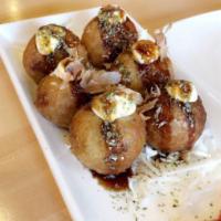 Takoyaki · Fried octopus balls drizzled with takoyaki sauce, Japanese mayo, and topped	with bonito flak...
