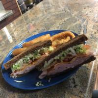 Smoked Turkey Club · Smoked turkey, crisp bacon and cheddar cheese with mayo lettuce and tomato. Served on lightl...