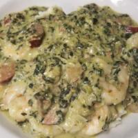 Grits Antonio · Creamy, cheesy grits topped with plump tender shrimp, spicy andouille sausage and crispy bac...