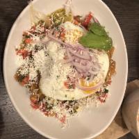 Chicken Chilaquiles · Housemade tortilla chips, avocado, cotija cheese, red onion, sour cream, tomatillo salsa, tw...