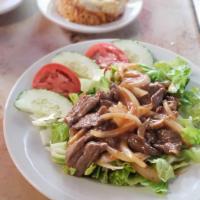 Steak Luk Lak · Marinated steak slices laid on top of lettuce, mixed with onions. Comes with side of fried r...
