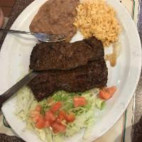 Carne Asada Dinner · Skirt Steak. Steaks are charcoal broiled to perfection. Served with rice, beans and tortilla...
