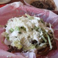 Tostada · Fried corn tortilla, topped with beans, your choice of meat, lettuce, sour cream and cheese.
