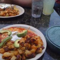 Huevos Rancheros Breakfast · A corn tortilla layered with veggie beans, 2 eggs over medium and homemade ranchero sauce to...