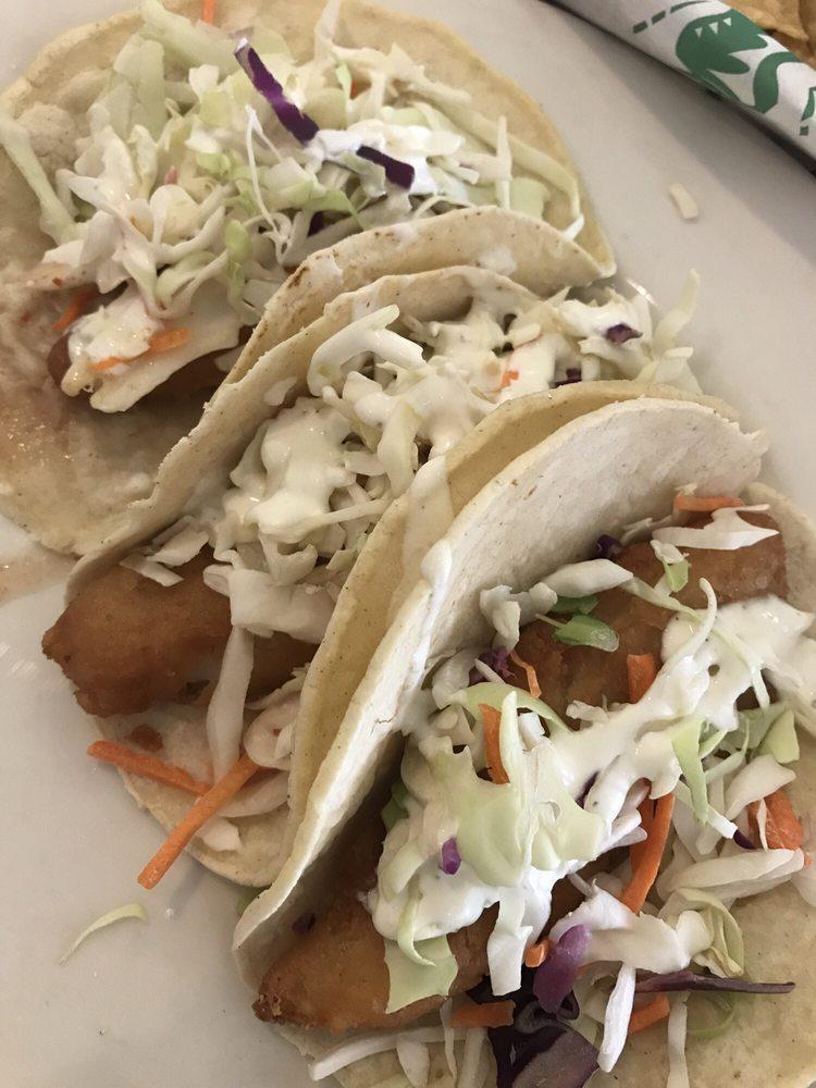 Azul Fish Tacos · Hand dipped in our signature batter and cooked to a crispy perfection, topped with azul white sauce, mild salsa and fresh cabbage, served on a warm stone-ground corn tortilla and garnished with a slice of lime.