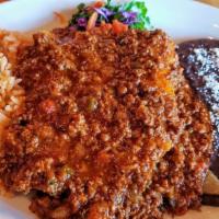 Enchiladas Texanas · Ground beef enchildas topped with chili con carne sauce.