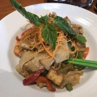 Pad Kee Mow · Wok tossed, big flat rice noodles, egg, garlic, chilies, bell pepper, tomatoes, and basil le...