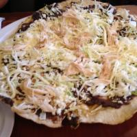 Tlayuda Tradicional · Critics favorite. Imported tortilla tlayuda layered with asiento spread, black beans paste a...
