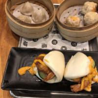 Grande Shrimp Bao · Two steamed bao buns stuffed with shrimp, fresh cucumbers, sprinkled cilantro with a light d...