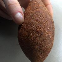 Kibbeh · One piece. Finely ground beef and cracked wheat, stuffed with seasoned minced, onion, and de...