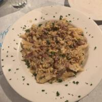 Carbonara · A flavorful combination of prosciutto, egg, and caramelized onion in a white cream sauce ser...