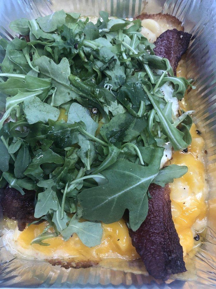 Breakfast Mac · Mac-n-cheese, candied bacon crust, 2 sunny side up fried eggs, lopped with dressed arugula.
