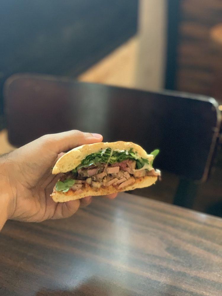 Porchetta Sandwich · Thinly sliced italian roast pork belly with garlic and fennel seed, pickled red onions, arugula, red bell pepper jam spread, sliced provolone on ciabatta bread.