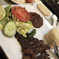 Carne Asada · Servido con arroz, frijoles y ensalada. Grilled beef steak served with rice, beans and salad.