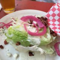 South Austin Wedge Salad · Crisp iceberg lettuce, blue cheese dressing, pickled onions, and bacon bits.