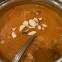 Butter Chicken · Boneless chicken cooked in a creamy sauce with herbs and butter garnishes with almonds.