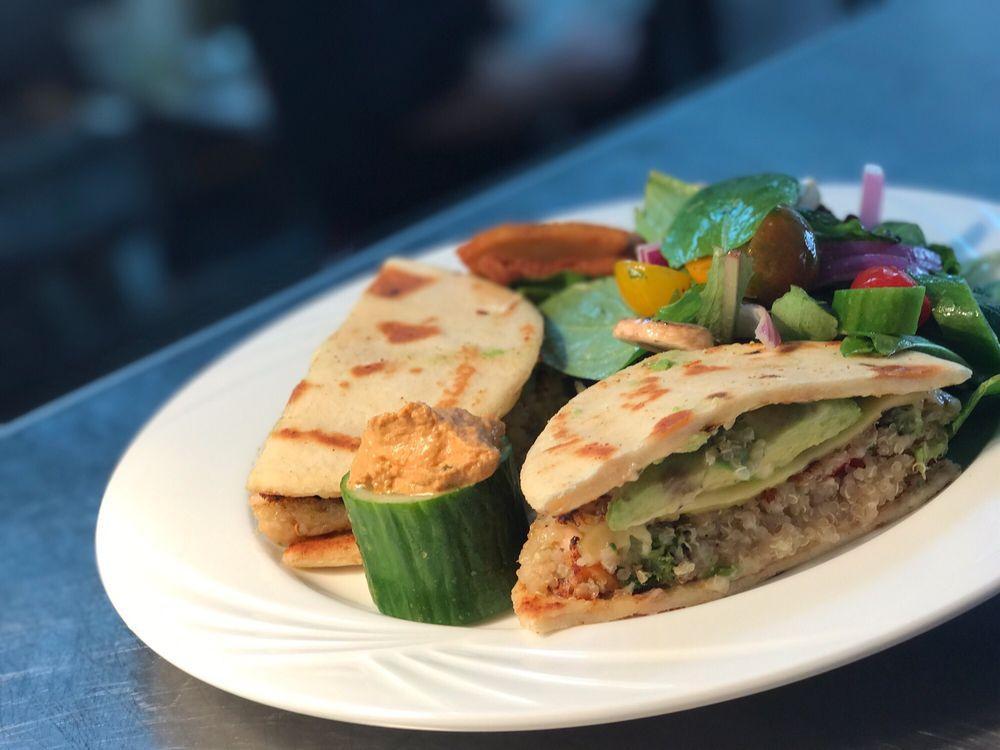 Quinoa Burger · Vegan. Seared and served on toasted naan bread with avocado, vegan cheese and seasonal salad tossed in a lime vinaigrette. Vegetarian.