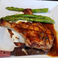 Dinner Bone in Pork Chop · Finished with a wild mushroom sauce, served with garlic mashed potatoes and asparagus.