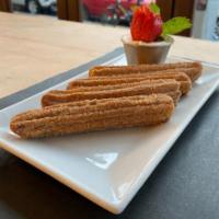 Churros · Cinnamon-dusted churros filled with dulce de leche served with chocolate dipping sauce.