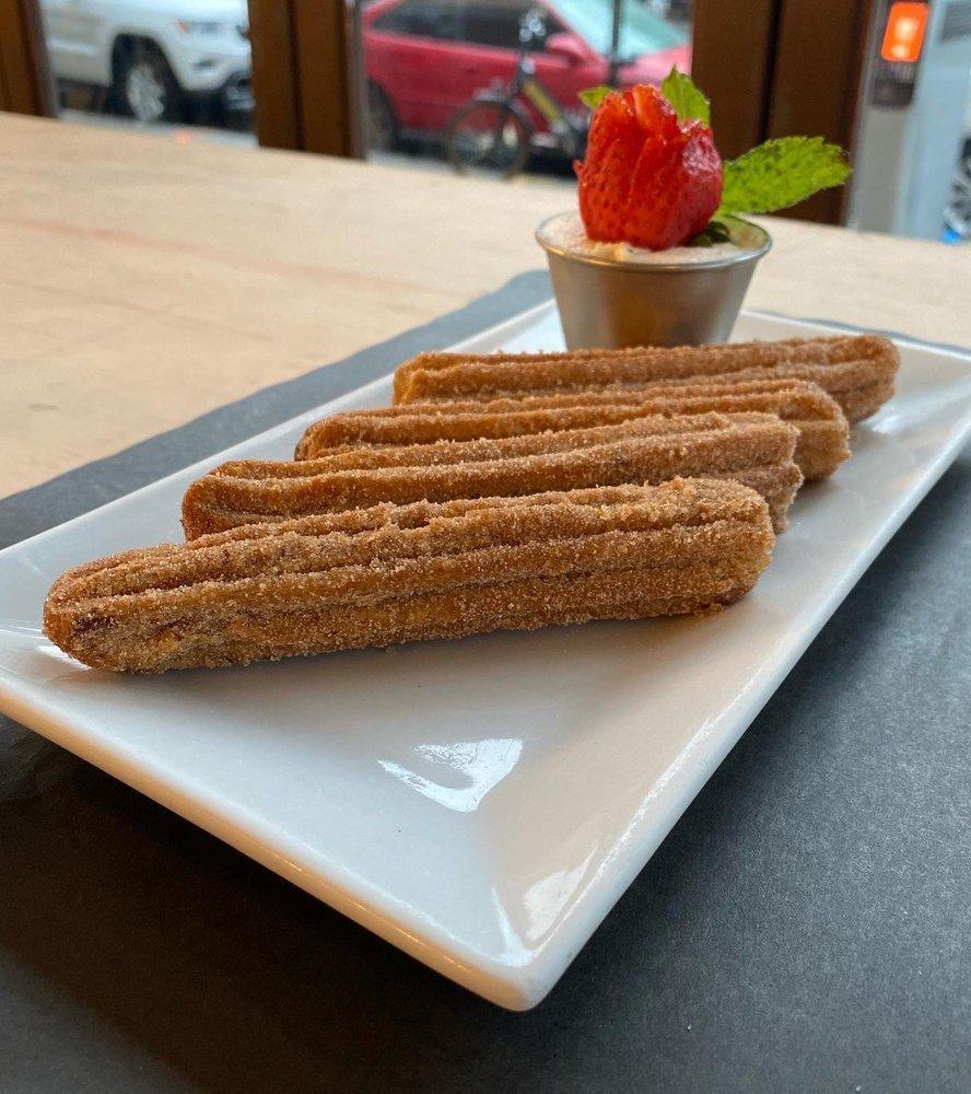 Churros · Cinnamon-dusted churros filled with dulce de leche served with chocolate dipping sauce.