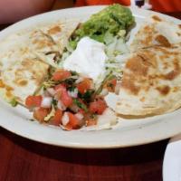 Quesadillas · Grilled, homemade flour tortillas stuffed with chicken, beef, or shrimp fajita and melted Mo...