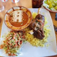 Lamb Shank · Tender lamb shank blended with our special spices served with rice and Arabic salad.