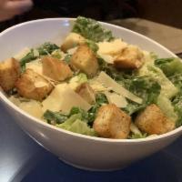 Caesar Salad · Romaine lettuce tossed with Caesar dressing and topped with shaved Parmesan and homemade cro...