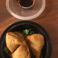 Samosa · Spiced potatoes and peas, crispy fried in a thin pastry pyramid.