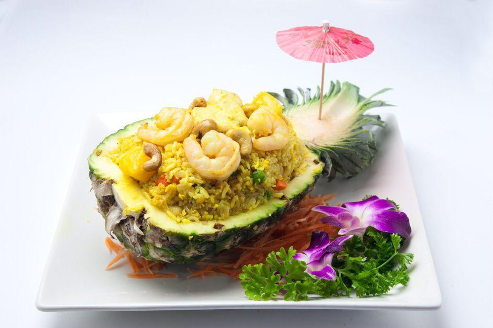 Pineapple Fried Rice · Steamed rice, Shrimp, chicken, pineapple, cashew nut, curry powder, pea-carrot, garlic and egg served in a pineapple shell.