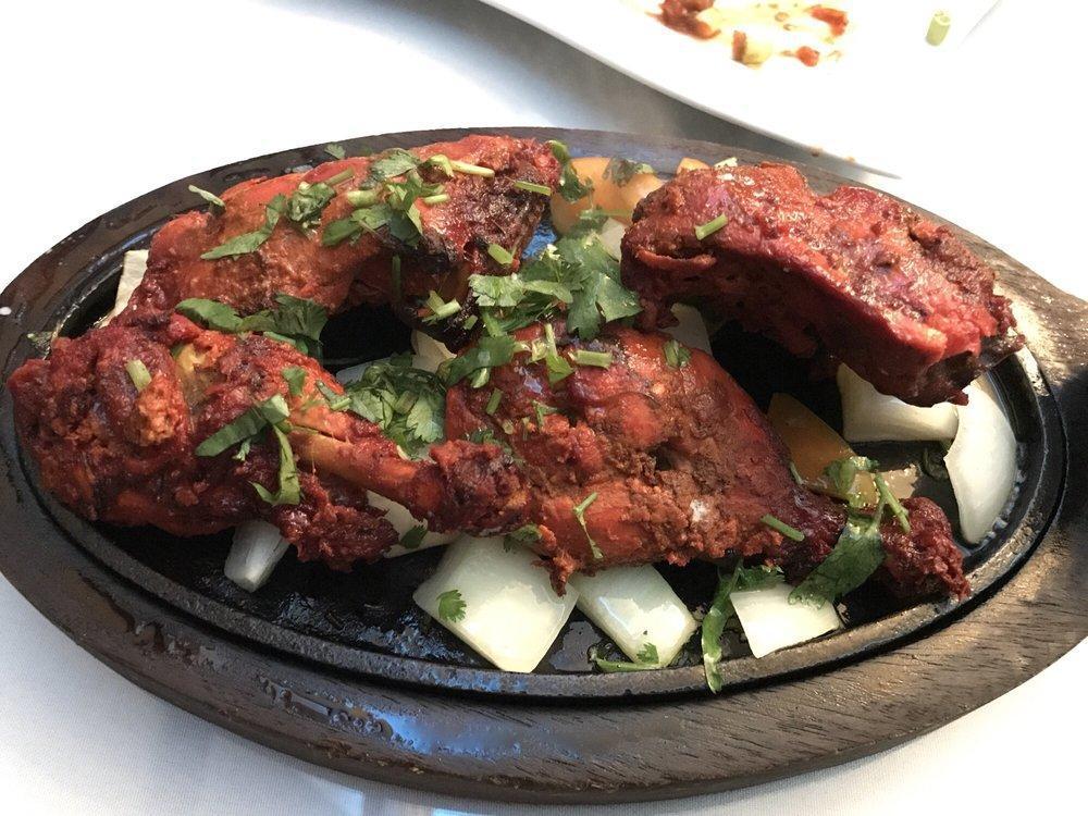 Tandoori Chicken · Chicken marinated in chef’s special spices. Baked in a special clay oven and served on a sizzler