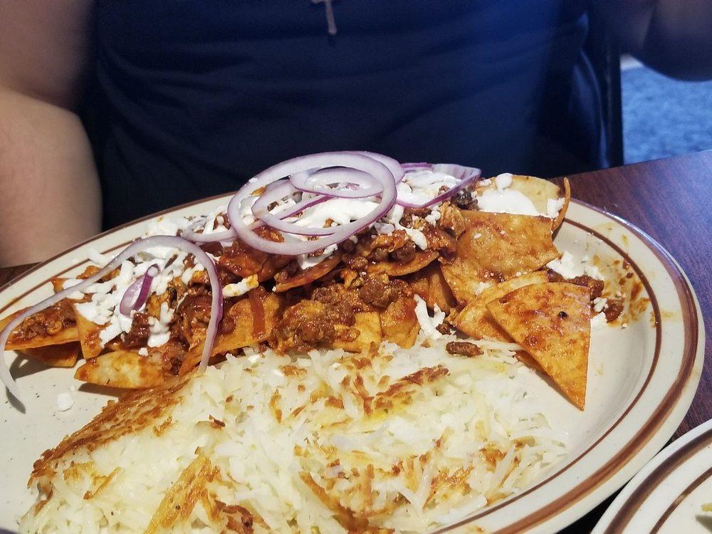 Chilaquiles · Chorizo, red sauce, corn tortilla chips, topped with 2 scrambled eggs, red onions, queso fresco and sour cream. Served with choice of side.