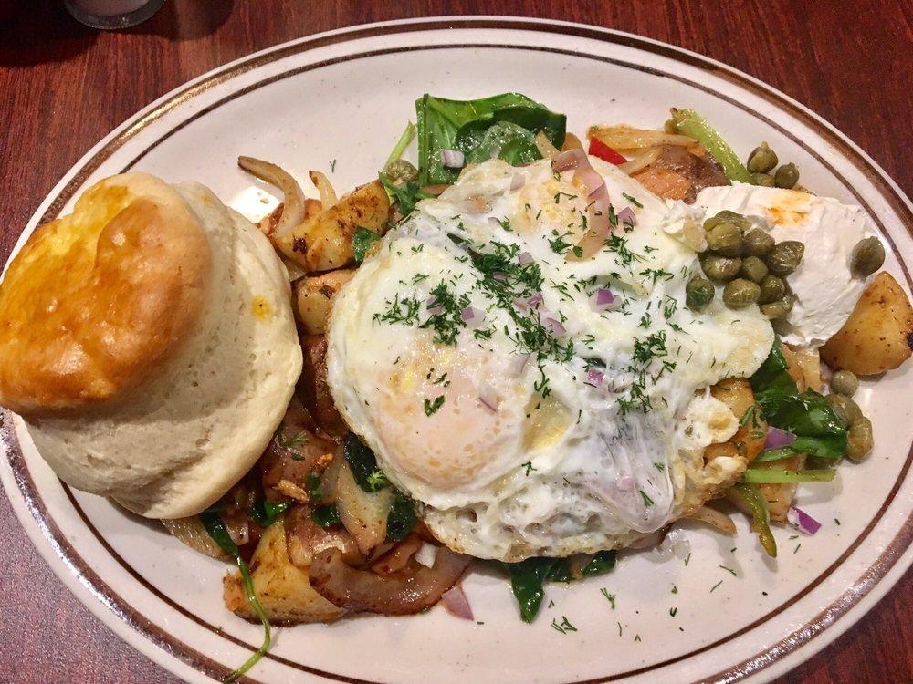 Smoked Salmon Skillet · Homemade country potatoes, spinach, smoked salmon, topped with red onion, cream cheese, capers and fresh dill. Topped with 2 eggs any style and served with a home made biscuit.