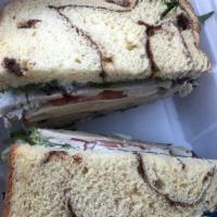 Turkey Apple Club Sandwich · Hand sliced turkey breast with red delicious apples, white cheddar, baby greens, tomatoes an...
